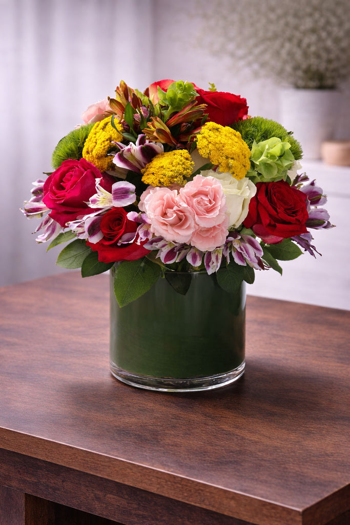 Admire is a vibrant floral arrangement with red roses, pink blooms, green hydrangea, yellow yarrow, and seasonal accents by Laguna Beach Florist.