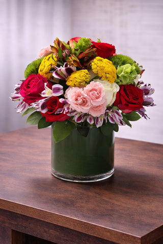 Admire is a vibrant floral arrangement with red roses, pink blooms, green hydrangea, yellow yarrow, and seasonal accents by Laguna Beach Florist.