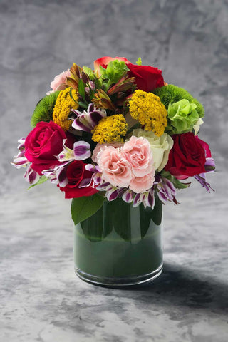 Mixed colorful flower arrangement in a round vase