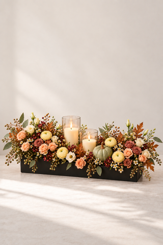 Gratitude Thanksgiving centerpiece with peach and ivory roses, ranunculus, seasonal foliage, pumpkin and pillar candles by Laguna Beach Florist