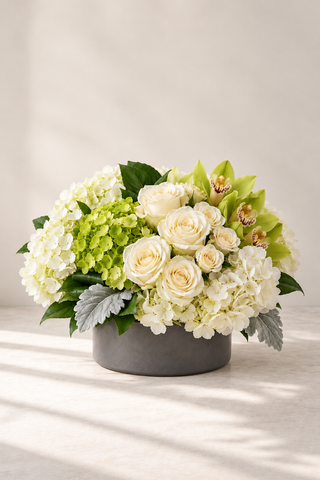 Floret all-around ivory and green floral centerpiece in a matte black bowl by Laguna Beach Florist