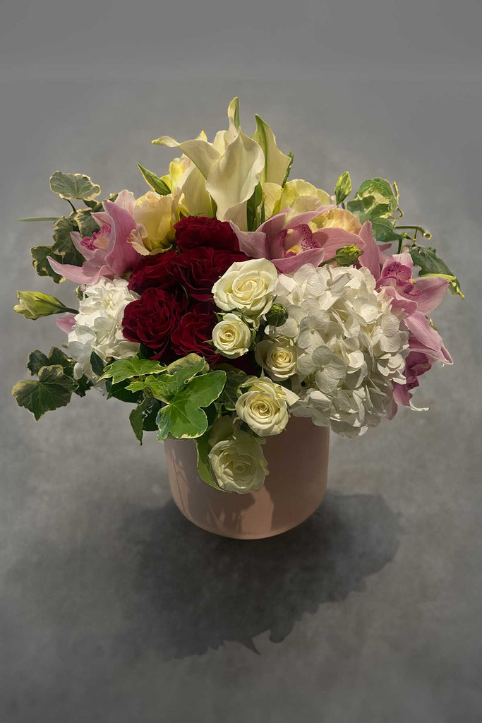 Mixed pink and white flower arrangement with roses, hydrangeas, calla lilies and orchids 