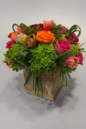 Mixed colorful flower arrangement in a wooden box